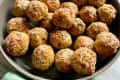Baked turkey meatballs in a gray bowl, with a green linen napkin at the bottom.
