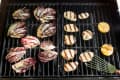 Grilled radicchio, halloumi slices, and lemon halves on a barbecue grill.