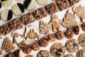Assorted holiday cookies including gingerbread men, pecan bars, and black-and-white cookies on a white surface.