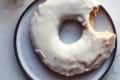 sour cream doughnut on a plate with a bite taken out