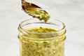 head on shot of italian dressing being spooned out of a small jar.