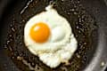 overhead shot of a fried egg being coked with the two fats method.