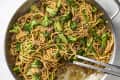 overhead shot of beef and broccoli noodles in a silver pan