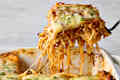 head on shot of baked spaghetti in a baking dish, with a piece taken out of the dish