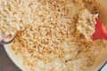 someone is pouring rice krispies into pot with marshmallow and other rice krispies