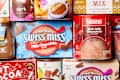 Overhead shot of an assortment of hot cocoa packaging, like swiss miss, lake champlain and nestle.