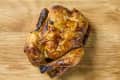 overhead shot of a rotisserie chicken on a wood cutting board.