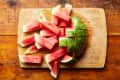Watermelon slices tumble down from cut watermelon half.