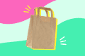 Brown paper bag with handles on a colorful abstract background.