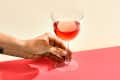 A glass of rose on a pink surface