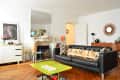 Living room with black leather sofa, "PARIS" pillows, green coffee table, fireplace, and globe decor.