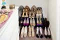 Organized closet with colorful clothes on hangers, shoes neatly arranged below, and boxes on the shelf above.