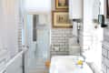 A bathroom with white subway tile on the bottom half of the wall.