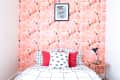 A single bed with mattress, covered in checkered bedsheet, sits against a floor-to-ceiling photo of swans