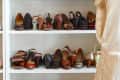 A six-tier shoe storage cabinet filled with different styles of shoes