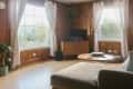 Living room with wood paneling, large windows, a TV on a wooden stand, a round coffee table, and a beige sofa.