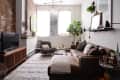 Cozy living room with brown leather sofa, patterned armchair, wooden TV stand, and large potted plant by the window.