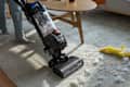 Someone vacuuming up a destroyed pet toy with a Bissell Vacuum Cleaner