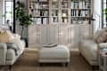 Cozy living room with light-colored sofas, a coffee table, and a tall bookshelf filled with books and decor.