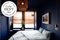 Dark blue bedroom and bed with cool toned linens with best list seal in upper leg