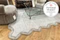 Photo of the Tufted Wool Scalloped Border Rug staged with furniture at the Anthropologie store. Personal Shopper seal in upper right