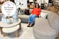 Someone testing a sofa at West Elm and a personal shopper seal in the upper corner