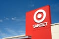 Red Target store sign with logo against a clear blue sky.