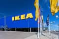 Large blue IKEA store exterior with yellow logo, surrounded by flags.