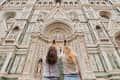 Two women photographing the ornate facade of a historic cathedral.