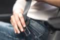 Passenger woman fastening seat belt in the car, safety concept