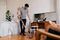 man cleaning bedroom with vacuum cleaner