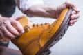 Closeup of Male Hands with Polishing Brush for Tan Brogue Derby Boots. Horizontal Image Orientation
