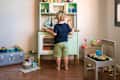 Little boy plays with a toy kitchen at home during quarantine