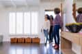 Smiling female customers entering through front door with real estate agent