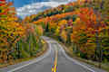 The view of autumn trees along a curve in the road along Highway 3 in the Adirondacks near Saranac Lake, Upstate New York.  Highway 3 goes through the Adirondacks and most scenic between Saranac Lake and Tupper Lake.