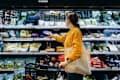 woman with shopping cart, carrying a reusable shopping bag, shopping for fresh organic fruits and vegetables in supermarket. Environmentally friendly concept.