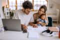 Young family with baby going over finances at home.