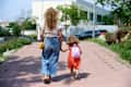 Mother walking daughter to school on a sunny day