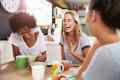 Three female friends laughing at breakfast