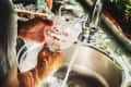 Close view of man washing glass in the kitchen.