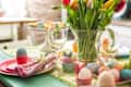 Colorful decorated Easter Place Setting with Easter Eggs, flowers on the table