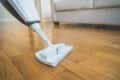 Cleaning the floor with a dry steam cleaner.