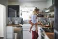 Mid adult father carrying daughter while cooking food in kitchen