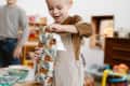 Little boy opening a gift. other gifts and another child in photo