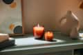 Burning candles near modern decorations