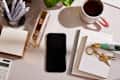 photo of desk in home office with note pads, calculator, pens, iphone
