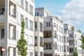 Modern white apartment buildings with balconies and greenery.