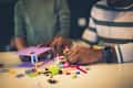 Worthy of creative hands. African American father and daughter playing with cubes. Focus on hands. Close up.