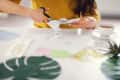 Young brunette woman creating her Feng Shui wish map using scissors