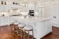 Beautiful kitchen in new traditional style luxury home. Features white island, counters, and cabinetry, and dark hardwood floors